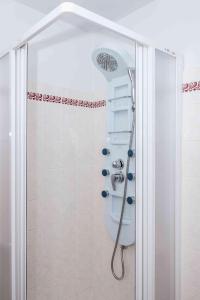 a shower with a shower head in a bathroom at Penzion U Michala in Prášily