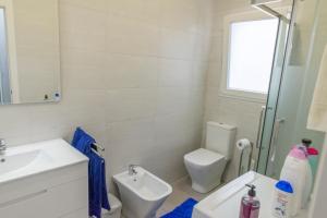 Un baño blanco con lavabo e inodoro. en Apartamento cerca de la Playa y el Centro, en Valencia 8 fotos más