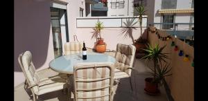 uma mesa e cadeiras numa varanda com uma garrafa de vinho em Home From Home em Lagos