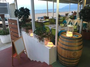 un ristorante con una botte, tavoli e una spiaggia di Case Playa a Balestrate