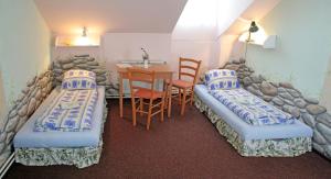 a room with two beds and a table and a table and chairs at Penzion U Michala in Prášily