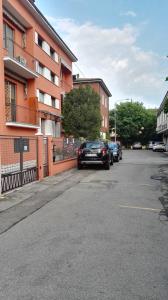 un coche aparcado en una calle al lado de un edificio en Appartamento Modena Park, en Módena
