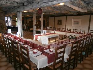 a long dining room with a long table and chairs at auberge du pied des monts in Grivy-Loisy