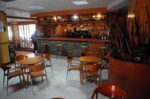 a restaurant with tables and chairs and a fireplace at Hotel Gomar in San Martín de Moncayo