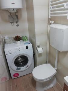 a bathroom with a washing machine and a toilet at Apartman Centar 1 in Užice