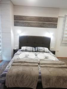 Apartman Centar 1 في أوزيتشي: غرفة نوم بسرير كبير عليها مناشف