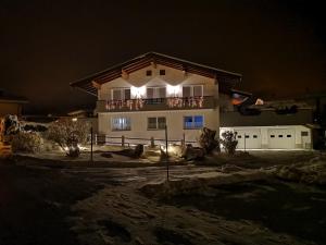 ein Haus in der Nacht mit Lichtern davor in der Unterkunft Ferienwohnung Obermoser in Sankt Ulrich am Pillersee