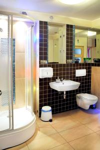 La salle de bains est pourvue d'un lavabo, de toilettes et d'une douche. dans l'établissement Wood Creek Apartments, à Wrocław