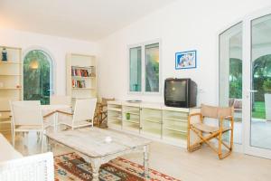 a living room with a tv and a table and chairs at Gli Ulivi Rosamarina Ostuni in Rosa Marina
