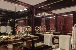 a bathroom with two sinks with mirrors and towels at The Chatwal, The Unbound Collection by Hyatt in New York +102 photos