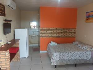 a small room with a bed and a refrigerator at Refúgio Canaã in Retiro Grande