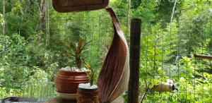 deux plantes en pots assises à côté d'une clôture dans l'établissement Pousada Vertente das Águas, à Lumiar