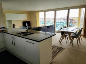怀特黑Harbourside Apartment的配有桌椅的厨房和客厅 更多11张照片