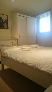 怀特黑Harbourside Apartment的卧室里有一张铺着白色床单的床和一扇窗户