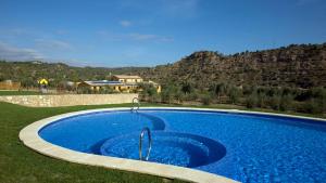 a large blue swimming pool in a yard with a mountain at Hotel Vilar Riu de Baix in Flix