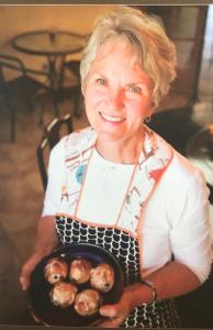 a woman holding a plate of donuts in a pan at Slot Canyons Inn Bed & Breakfast in Escalante