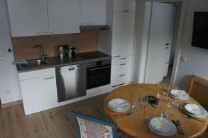 a kitchen with a wooden table and a kitchen with white cabinets at Ausblick Appartements mit Lungaucard in Sankt Michael im Lungau