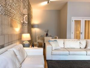 a living room with two white couches and a table at Baixa Chiado Áurea Apartment in Lisbon