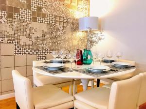 une salle à manger avec une table et des chaises blanches dans l'établissement Baixa Chiado Áurea Apartment, à Lisbonne