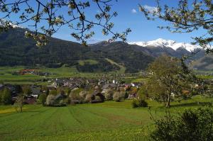 a small town in a valley with snow capped mountains at Ausblick Appartements mit Lungaucard in Sankt Michael im Lungau
