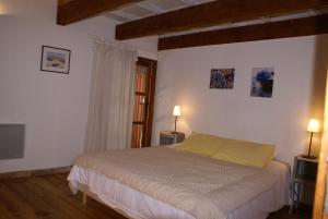 a bedroom with a bed and a window and two lamps at Mas Tolosan in Vauvert +26 photos
