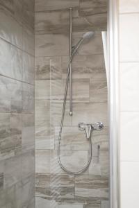 a shower with a shower head in a bathroom at Gasthaus-Pension Hofmann in Oberdachstetten