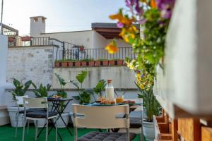 a table and chairs on a balcony with flowers at B&b Oltre l'Arco in Molfetta