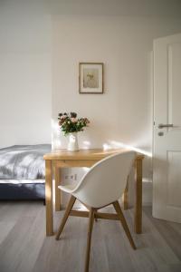 una scrivania con sedia bianca in una camera da letto di Ferienwohnung Charlotte a Weisenheim am Sand