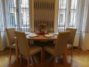 a dining room table with chairs and a table with flowers on it at West10 STAR City Center in Budapest