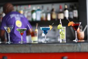 a row of four cocktails sitting on a bar at Pelican Bay Hotel in Freeport