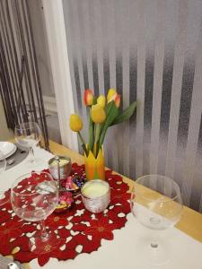uma mesa com copos de vinho e um vaso de flores em West10 STAR City Center em Budapeste