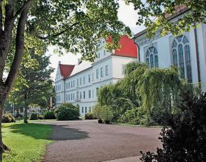 un gran edificio blanco con techo rojo en Hotel Moorbadstuben, en Bad Buchau