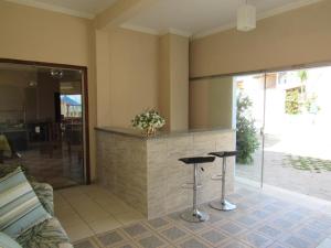 a kitchen with two bar stools and a counter at Franz Beach in Nova Viçosa