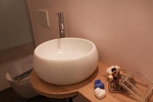a white sink on a wooden counter in a bathroom at Casa della Nonna in Zwalm