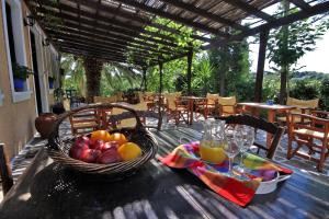 a table with a basket of fruit and glasses of orange juice at Vagia Traditional, Aegina Island in Vaia