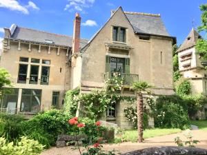 una vecchia casa con dei fiori davanti di Loire Valley Medieval Getaway a Rochecorbon