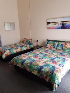 a bedroom with two beds and a picture on the wall at Wentworth Central Motor Inn in Wentworth