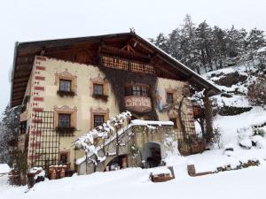 una grande casa con la neve sul davanti di Piburg Seebichlhof a Oetz