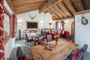a living room with a table and a dining room at Hotelino Petit Chalet in Celerina