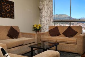 Sala de estar con 2 sofás y mesa en Residencial Emilio, en Cusco