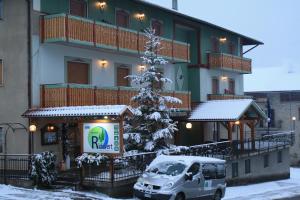 een busje geparkeerd voor een gebouw met een kerstboom bij Locanda Ridevert in Tione di Trento