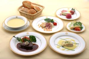 Nikko Kanaya Hotel في نيكو: طاولة بها صحون طعام وسلة خبز