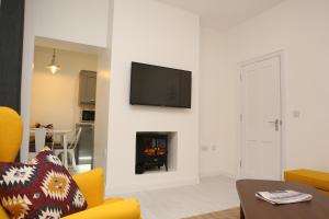 sala de estar con chimenea y TV en la pared en East Bridge Apartments, en Enniskillen