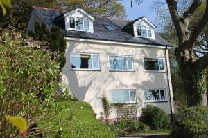 a white house with white windows and a tree at The Foretop in Cardiff