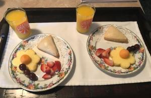 zwei Teller Essen auf einem Tablett mit zwei Gläsern Orangensaft in der Unterkunft Victoria Inn in Erie