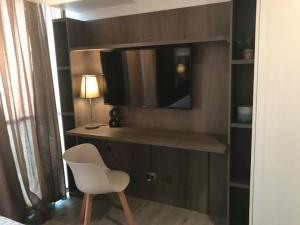 a room with a desk with a television and a chair at Costado Mall in Antofagasta