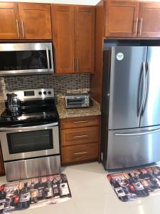 a kitchen with stainless steel appliances and wooden cabinets at Hamptons at Fairway across from AC Marriott Unit No3 in Kingston