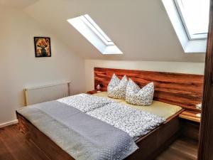 a bedroom with a bed with a wooden headboard and skylights at Landgasthof "Zur Linde" in Dreba