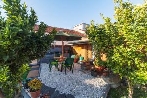 a backyard with a table and chairs and trees at Bairro Alegre, Casa do Porto in Porto