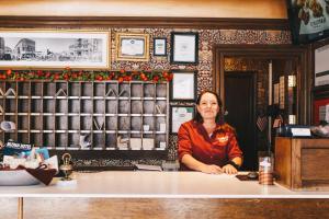 een vrouw die aan een balie in een koffiehuis zit bij Mizpah Hotel in Tonopah